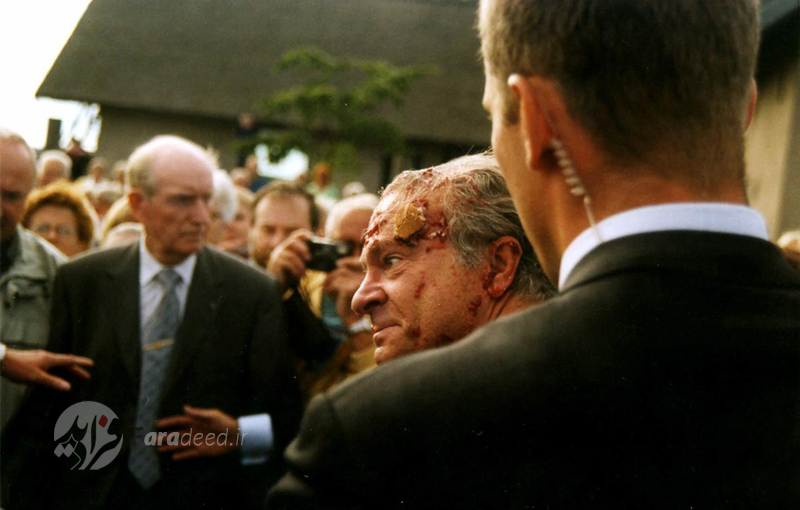 پادشاه "کارل گوستاو سوئد" در شهر "واربرگ" پس از آنکه یک جوان مهاجم کیک توت فرنگی به سمت او پرتاب کرد. 5 سپتامبر 2001 