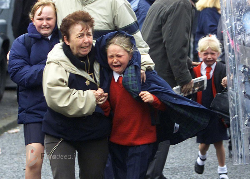 کودکان و والدین وحشت زده پس از انفجار یک بمب در جاده شمال "بلفاست" در ایرلند. 5 سپتامبر 2001 